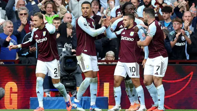 Emiliano Buendia celebrates scoring his team's third goal against Fulham with team-mates Matty Cash, Morgan Rogers, John McGinn and Evann Guessand