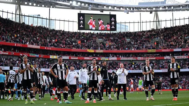 Newcastle players applauding the away support after defeat at Arsenal