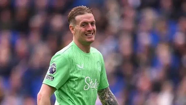 Jordan Pickford smiles while in action for Everton
