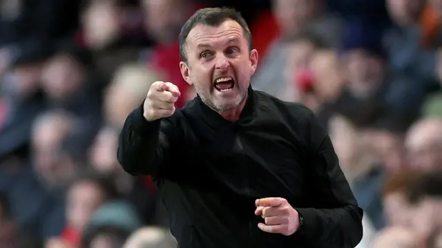 Nathan Jones, wearing a black jacket, points and shouts on the touchline during Charlton's 2-1 defeat to Ipswich