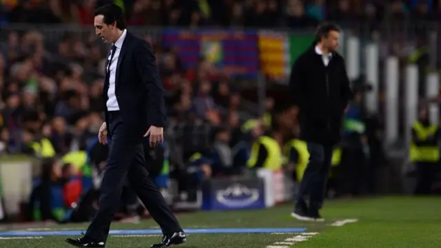 Unai Emery walks on the sideline with Luis Enrique in background