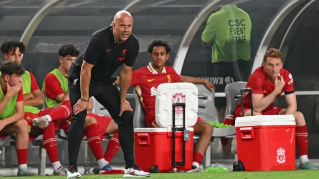 Arne Slot and the Liverpool bench watch on