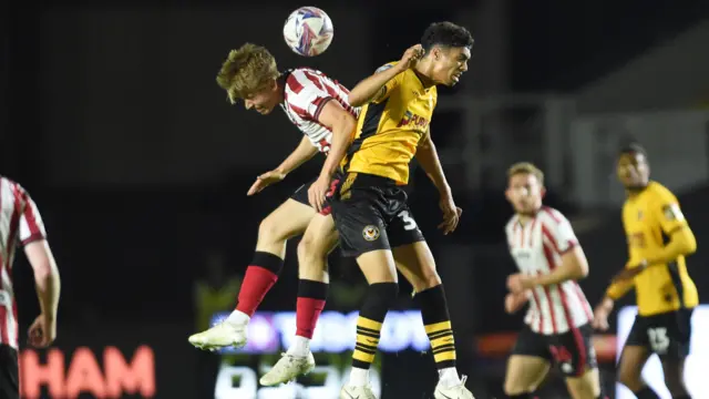 Noah Mawane of Newport County is challenged by Jordan Thomas of Cheltenham Town