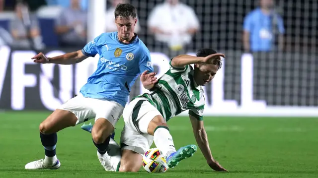 Manchester City and Celtic players challenge for the ball