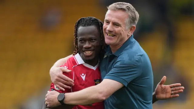Wrexham boss Phil Parkinson hugs player Issa Kabore 