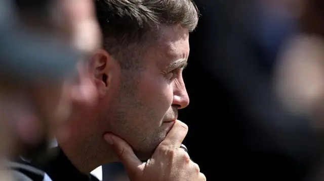 A close-up image of Fabian Hurzeler with his hand on his chin looking thoughtful