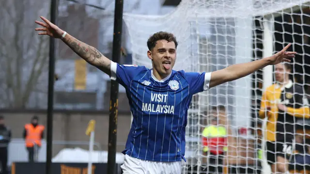 Cardiff City's Alex Robertson celebrates with arms in the air and his tongue out