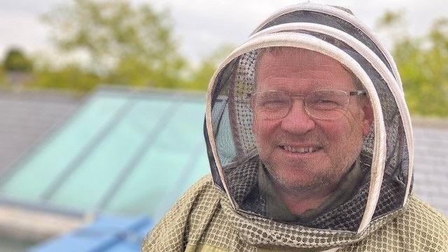 Mr Briggs on the roof of the Civic Centre smiles for the camera from inside his bee protection suit.