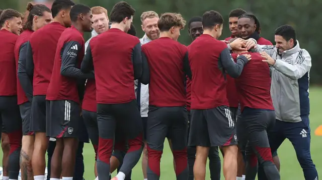 Arsenal boss Mikel Arteta interacts with a group of his Arsenal players during a training session