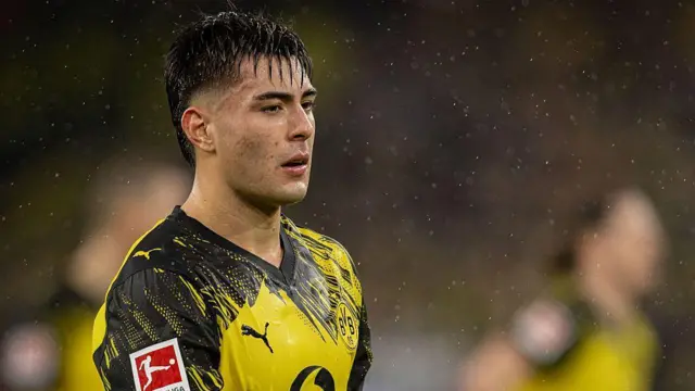 Aaron Anselmino looking across the pitch in the rain for Dortmund