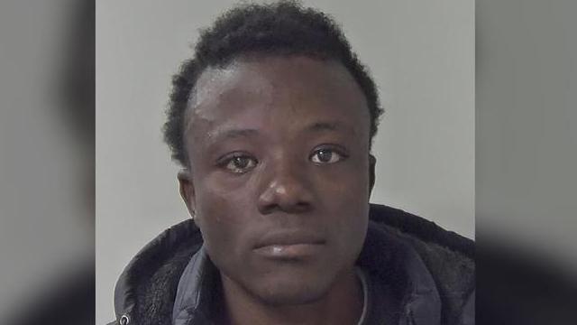 A police mugshot of a young man wearing a hooded jacket