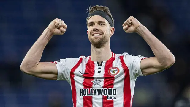 Kristoffer Ajer holds hands up in celebration at full-time for Brentford