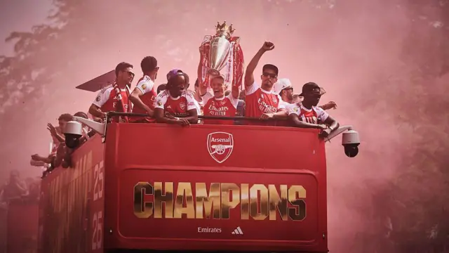 Martin Odegaard of Arsenal lifts the Premier League trophy on top of the Arsenal bus during the parade