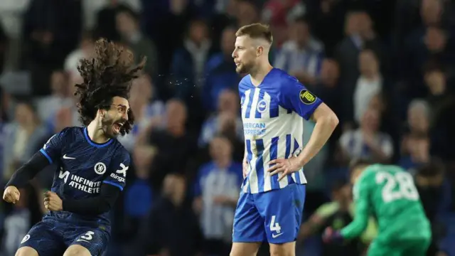 Adam Webster looks dejected as Marc Cucurella celebrates