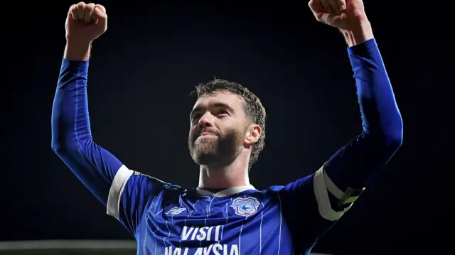 Calum Chambers smiles and raises both fists in the air celebrating a Cardiff City win