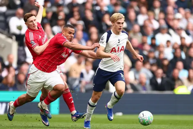 Lucas Bergvall dribbles with the ball with Murillo and Elliot Anderson in pursuit during last season's game between Tottenham and Nottingham Forest