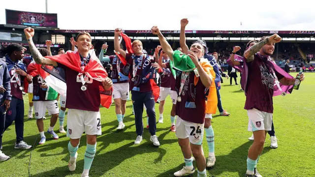 Burnley squad acknowledge the crowd following Championship promotion