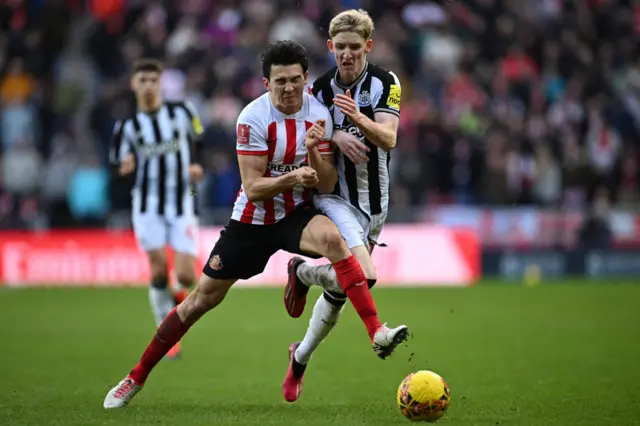 Luke O'Nien challenges with Anthony Gordon for the ball