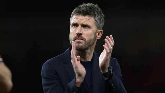 Manchester United's interim head coach Michael Carrick applauds fans/