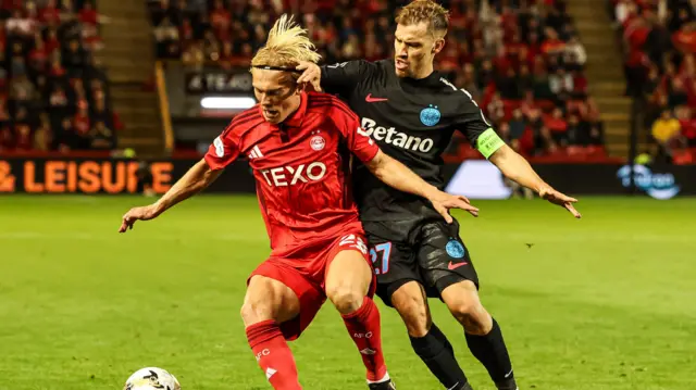 Aberdeen's Alexander Jensen and FCSB's Darius Olaru in action 