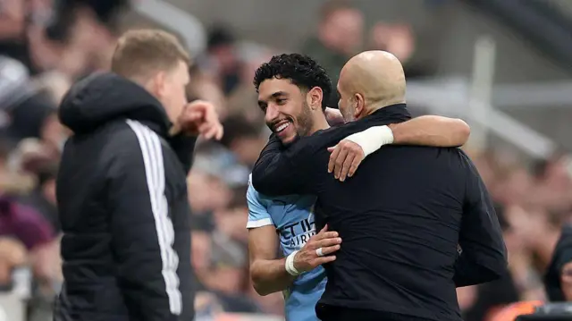 Omar Marmoush of Manchester City interacts with Pep Guardiola