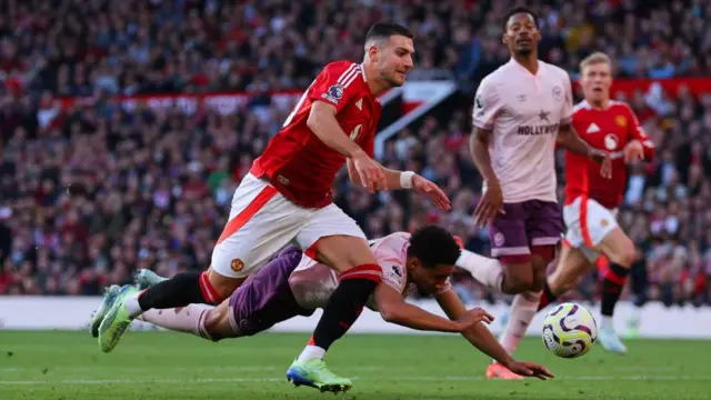 Diogo Dalot and Kevin Schade compete for the ball