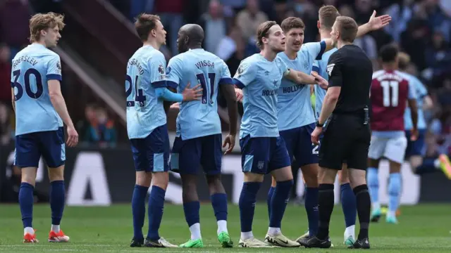 Brentford players argue with the referee