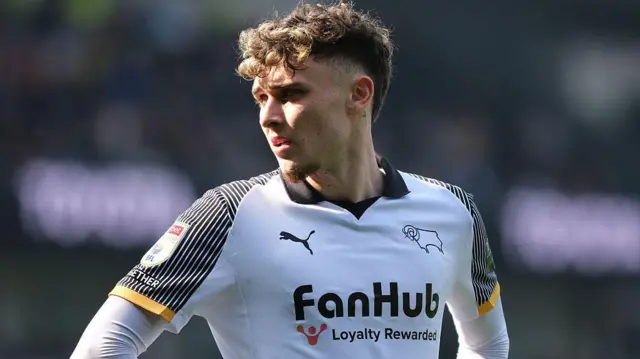 Bobby Clark pictured during a game wearing a white Derby County shirt with the club's Rams badge on it and the sponsor across the middle