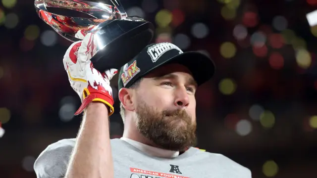 Travis Kelce with the AFC Championship trophy in 2025