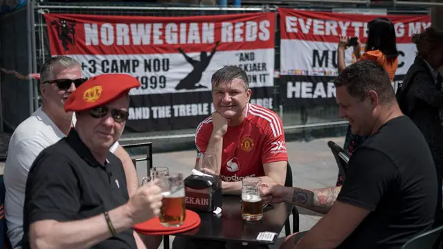 A group of four male Manchester United fans pose for a picture