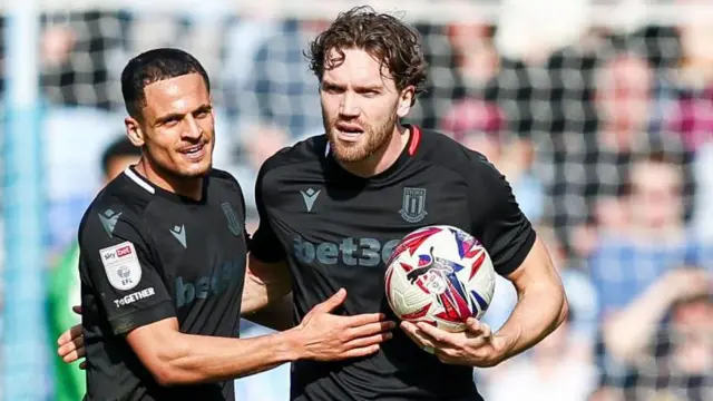 Stoke City's Sam Gallagher has the ball under his arm as he is congratulated by a team-mate after scoring a goal