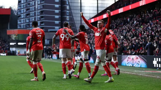 Sonny Carey holding out his arms in victory towards the crowd as his team-mates head to the tunnel at The Valley