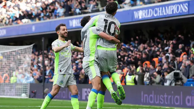 Rayan Cherki of Manchester City celebrates with Matheus Nunes and Bernardo Silva.