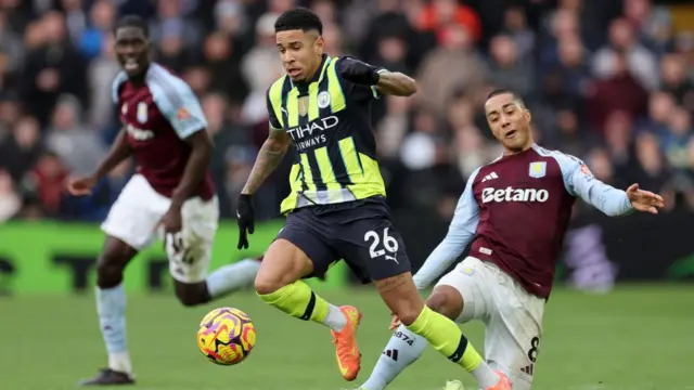 Savinho of Manchester City is tackled by Youri Tielemans of Aston Villa