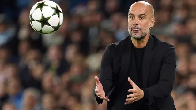 Pep Guardiola catches a ball on the touchline