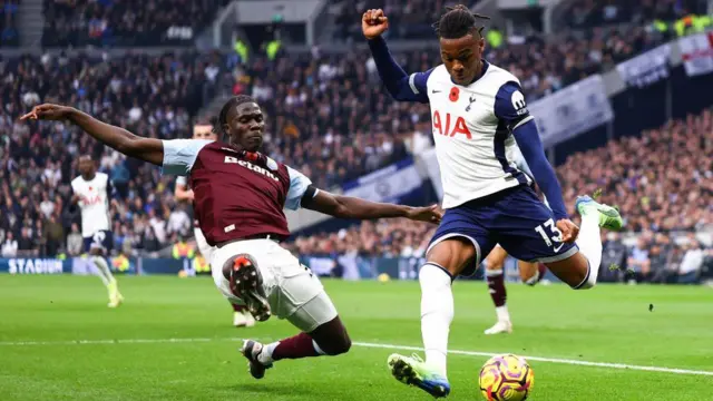 Amadou Onana of Aston Villa tackles Tottenham's Destiny Udogie