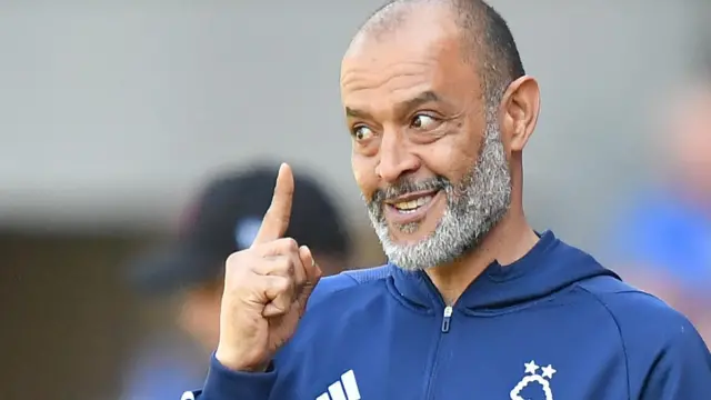 Nuno Espirito Santo raises the index finger on his right hand and smiles