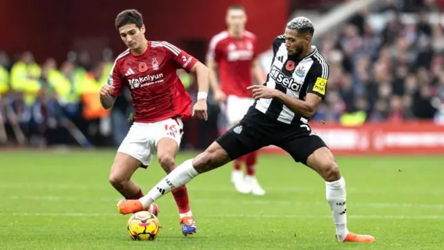 Nicolas Dominguez and Joelinton compete for the ball