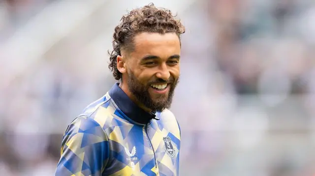 Dominic Calvert-Lewin smiles while warming up