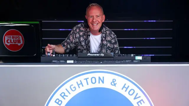 Norman Cook, better known as Fatboy Slim, at a DJ set with the Brighton badge in the forefront