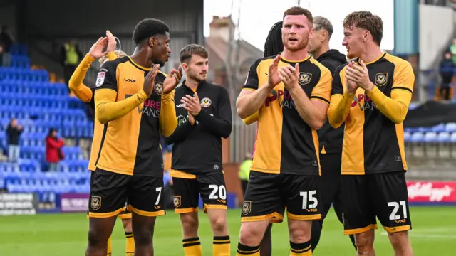 Newport County players applaud fans on the pitch at the end of a match
