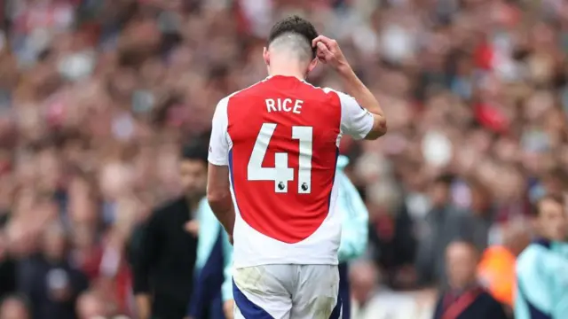 Declan Rice of Arsenal leaves the pitch after being shown a second yellow card 