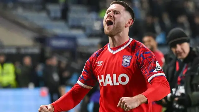 Wes Burns celebrates after a win with Ipswich. He wears the club's away colours.