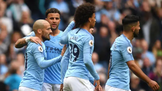 David Silva of Manchester City celebrates with teammates Kyle Walker, Leroy Sane and Sergio Aguero