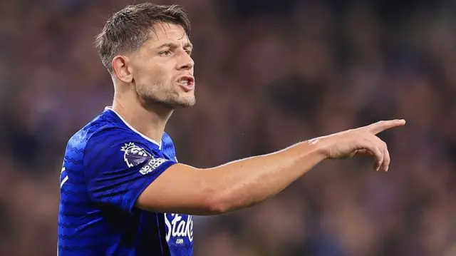 James Tarkowski wearing Everton's blue home shirt and pointing his finger as he issues instructions during a match