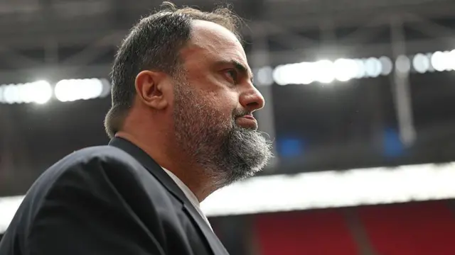 Side profile of Evangelos Marinakis looking on at Wembley