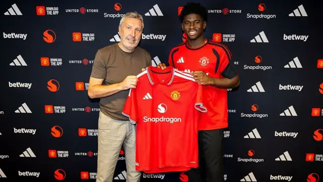 Carlos Baleba of Manchester United poses with Director of Football Jason Wilcox
