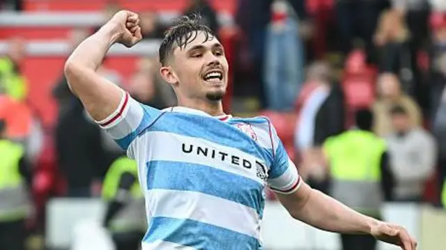 Callum Doyle celebrates a Wrexham win in front of the supporters