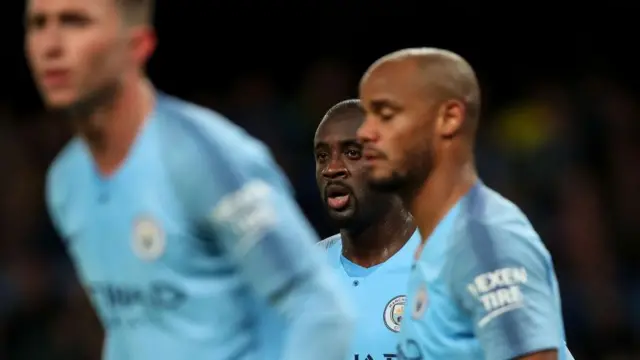 Yaya Toure in the background. Vincent Kompany in front of him as they play for Manchester City