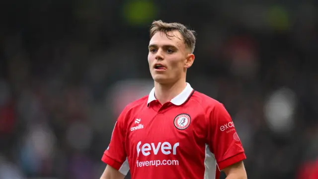 A close-up of Scott Twine licking his lips while wearing a Bristol City home kit
